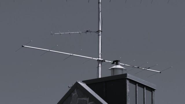 Black and white shot of antennae on top of a pump station.